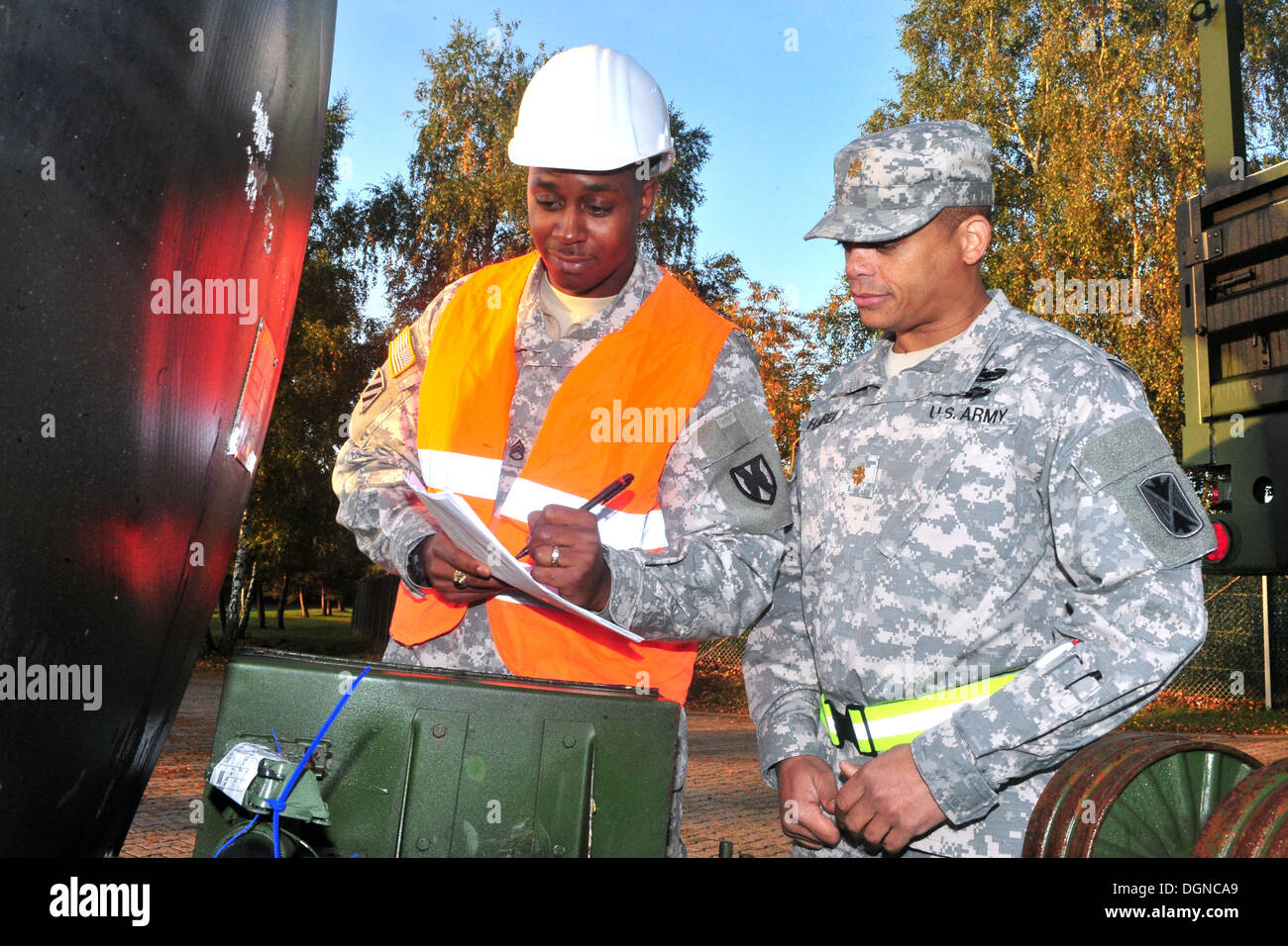 Il personale Sgt. Tyler P. Jackson (sinistra) il movimento di trasporto e installazione staging area supervisore con il ventunesimo Theatre supporto comando e un nativo di Queens, N.Y., recensioni un pezzo di attrezzatura con numero di serie con il Mag. Ernest J. Harrell, il Foto Stock