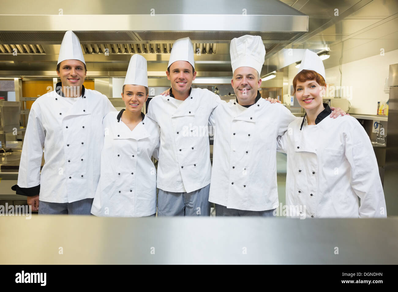 Cinque chef felice sorridente verso la telecamera Foto Stock