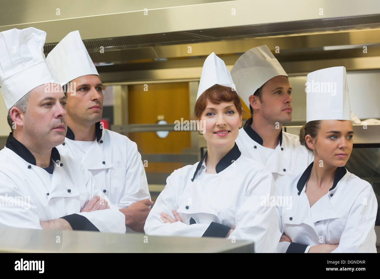 Team di chef che guarda lontano con una sorridente in telecamera Foto Stock