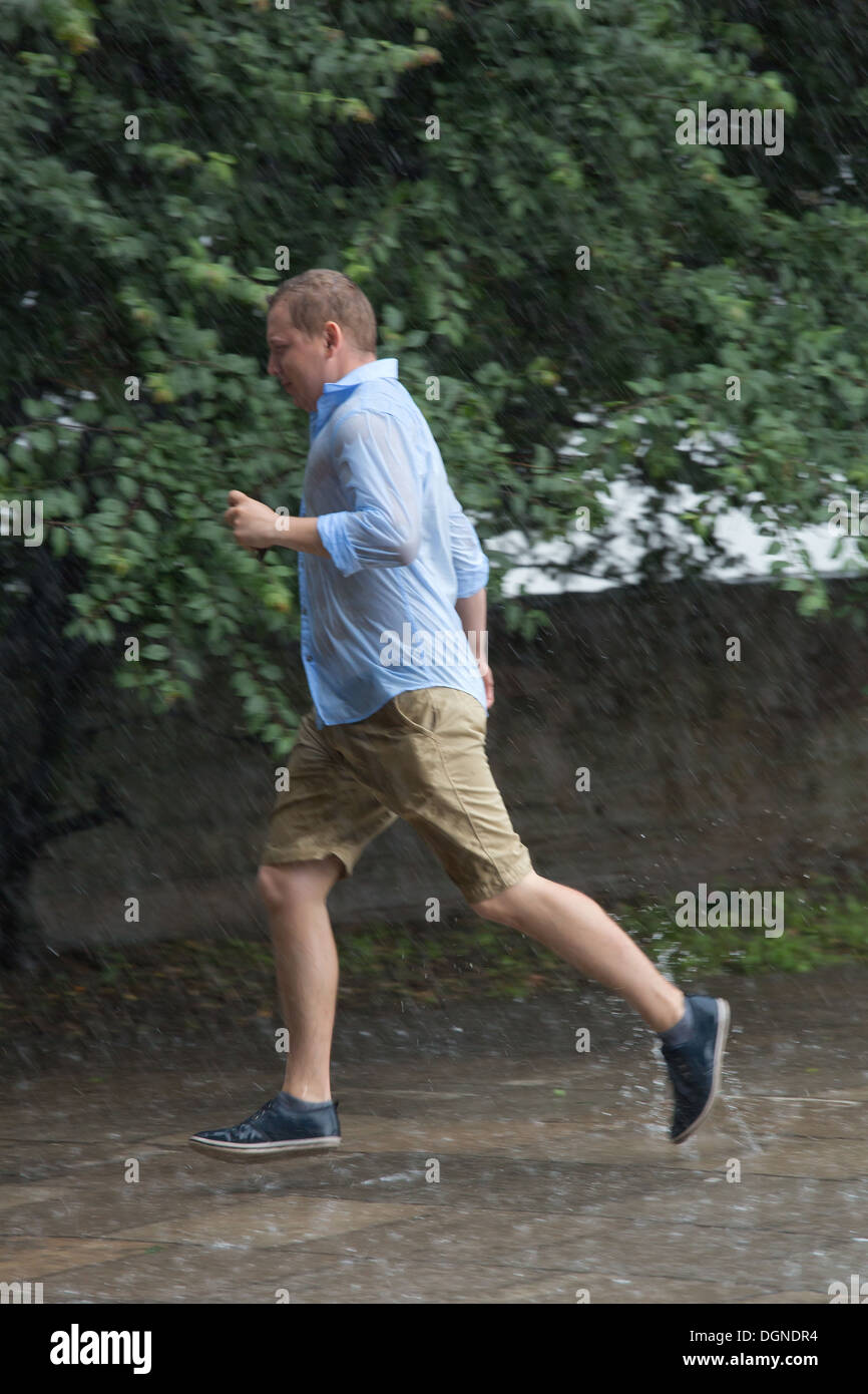 Varsavia, Polonia, intriso di un uomo cammina attraverso pozzanghere Foto Stock