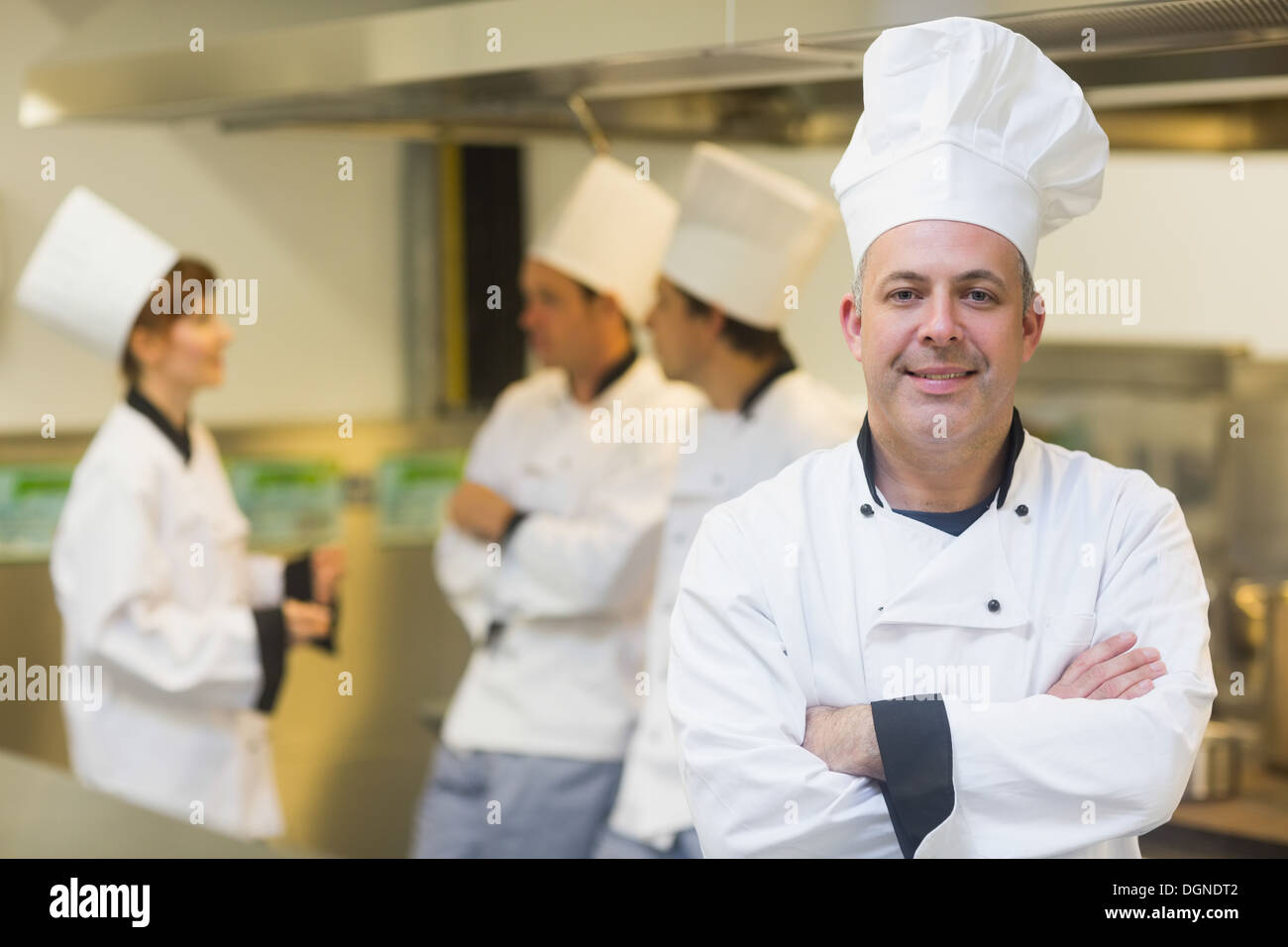 Maschio maturo chef in posa orgogliosamente in una cucina Foto Stock