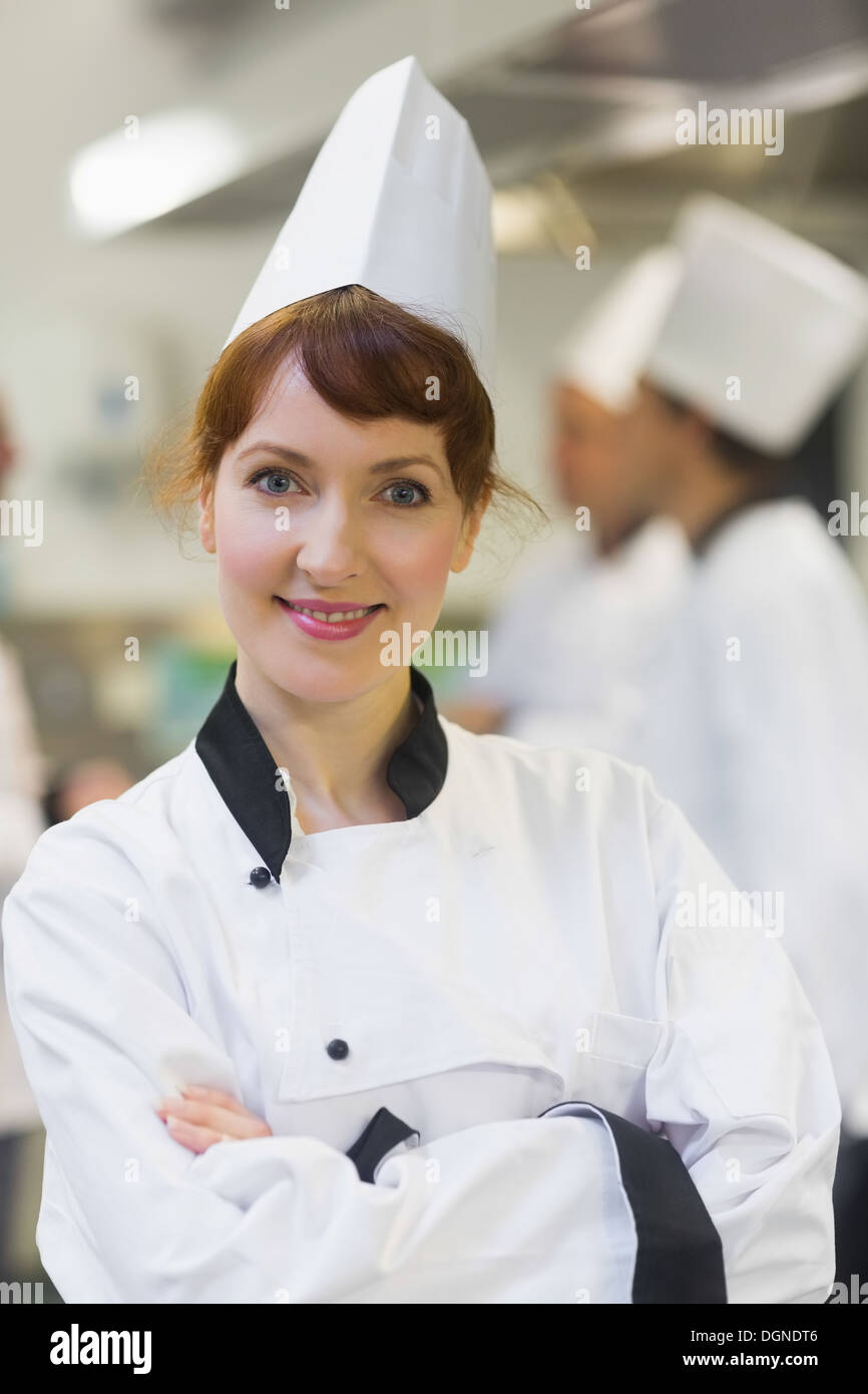 Lo chef femmina in posa orgogliosamente in una cucina Foto Stock