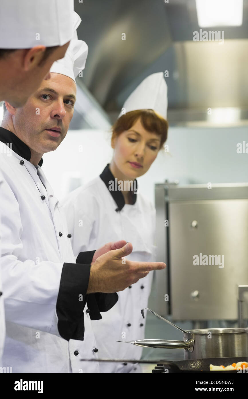 Maschio maturo cuoco spiegare qualcosa a un collega Foto Stock