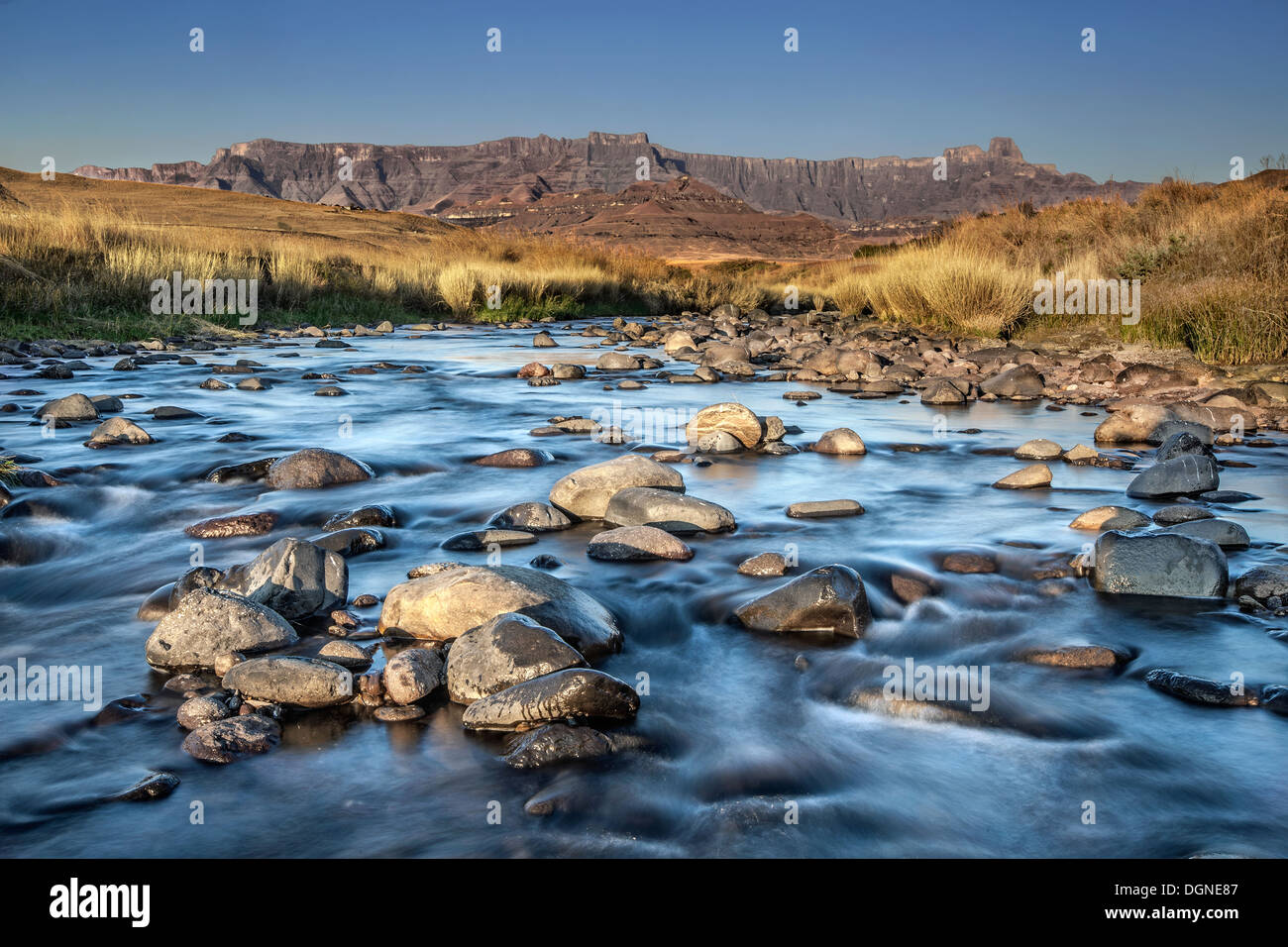 Un fiume scorre nella parte anteriore del Drakensburg Foto Stock