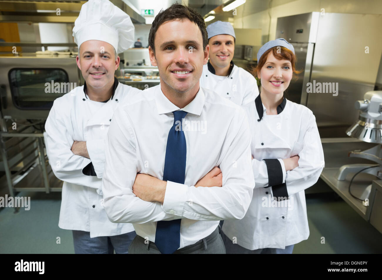 Il manager del ristorante in posa davanti al team di chef Foto Stock