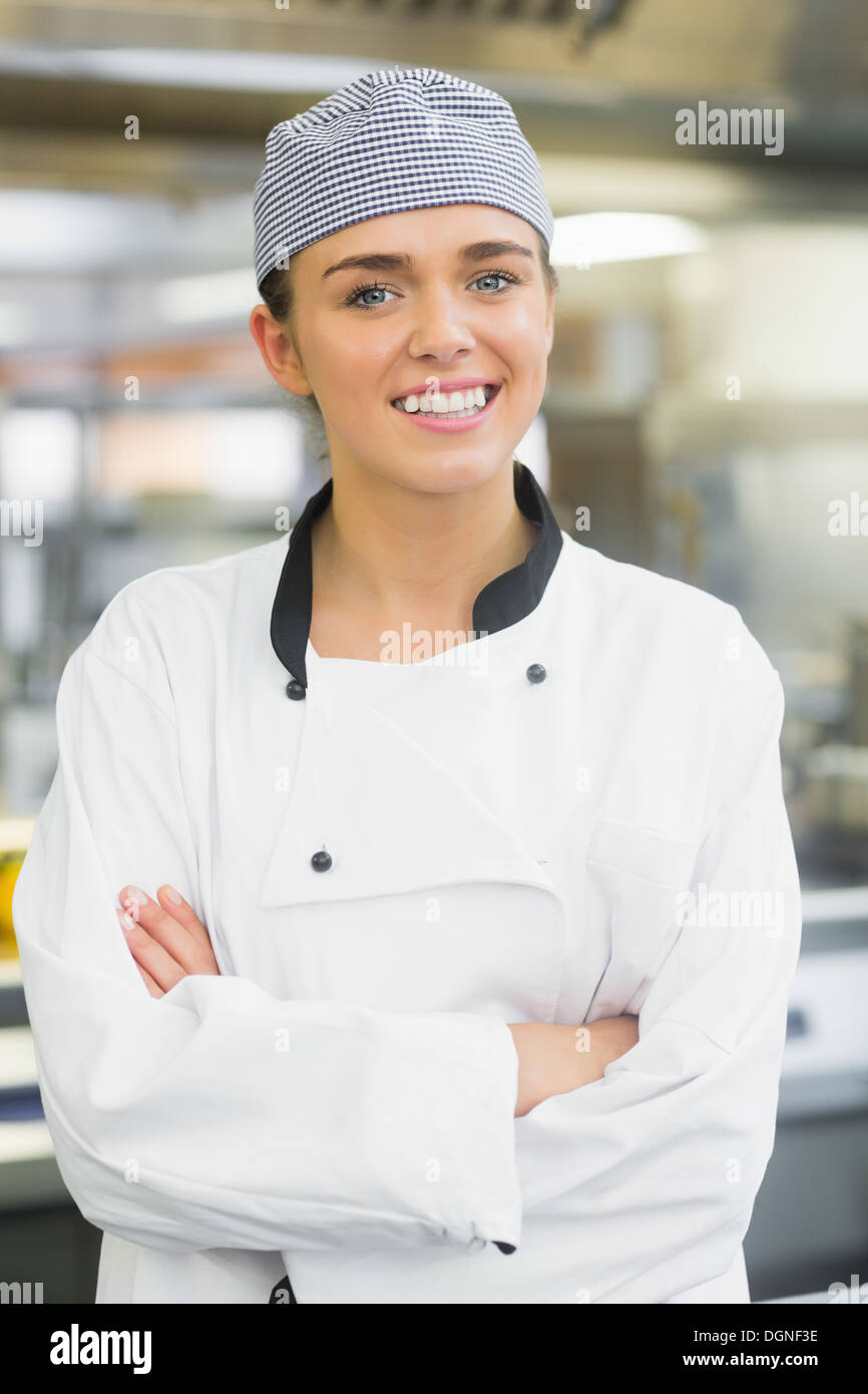 Giovani chef femmina in posa con bracci incrociati Foto Stock