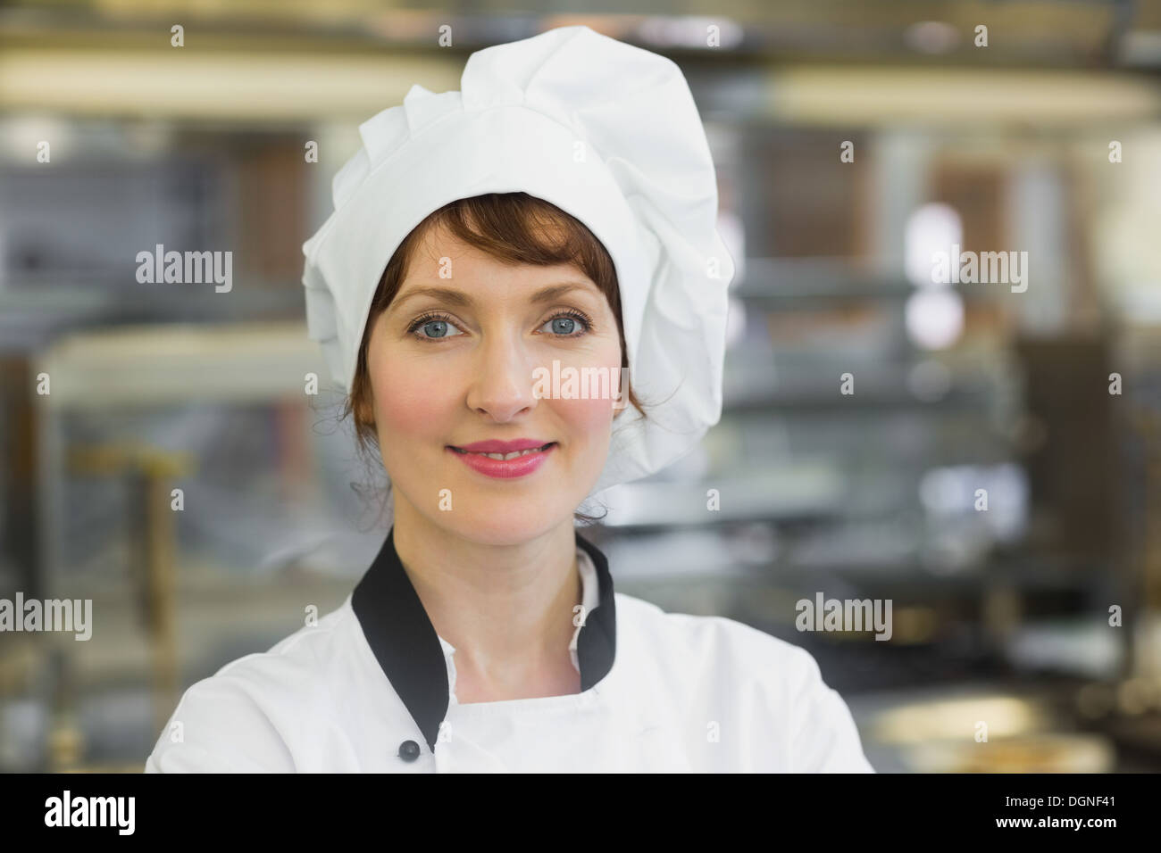 Felice chef femmina in posa di una cucina Foto Stock