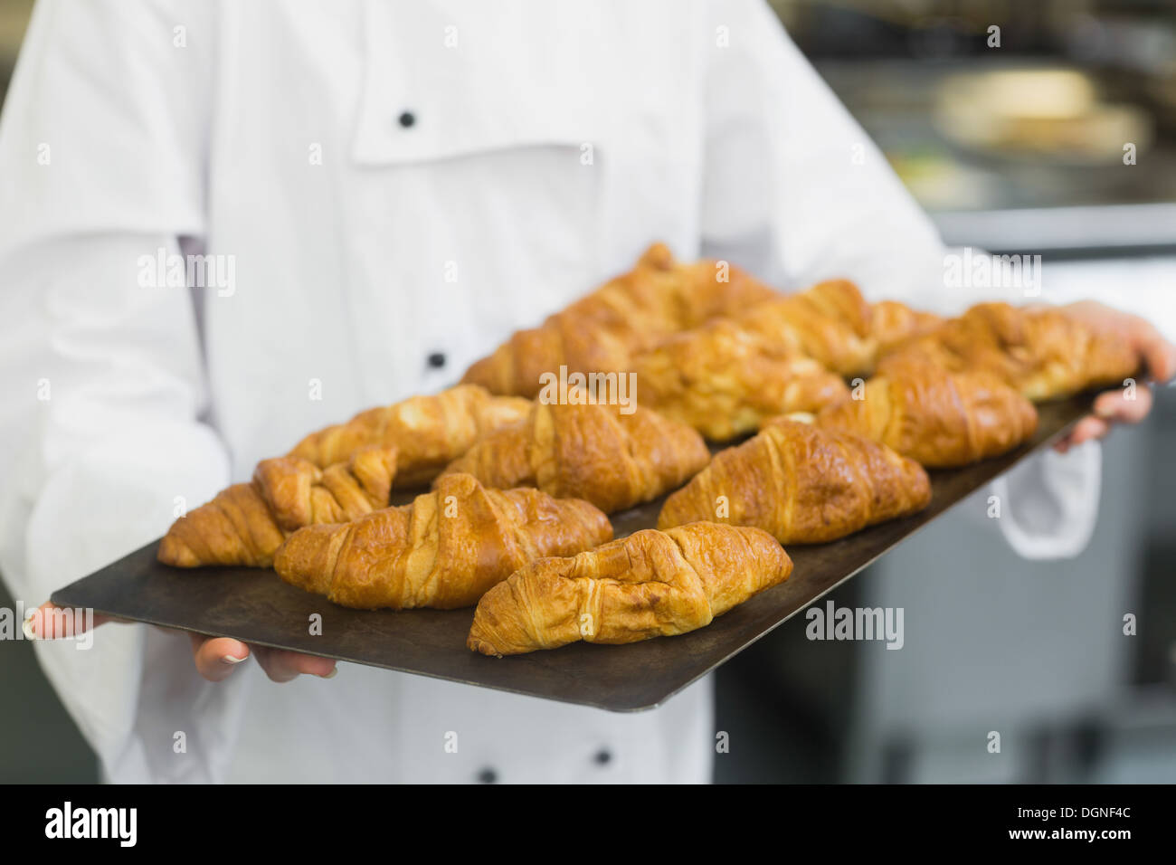 Baker presentando alcuni croissant Foto Stock