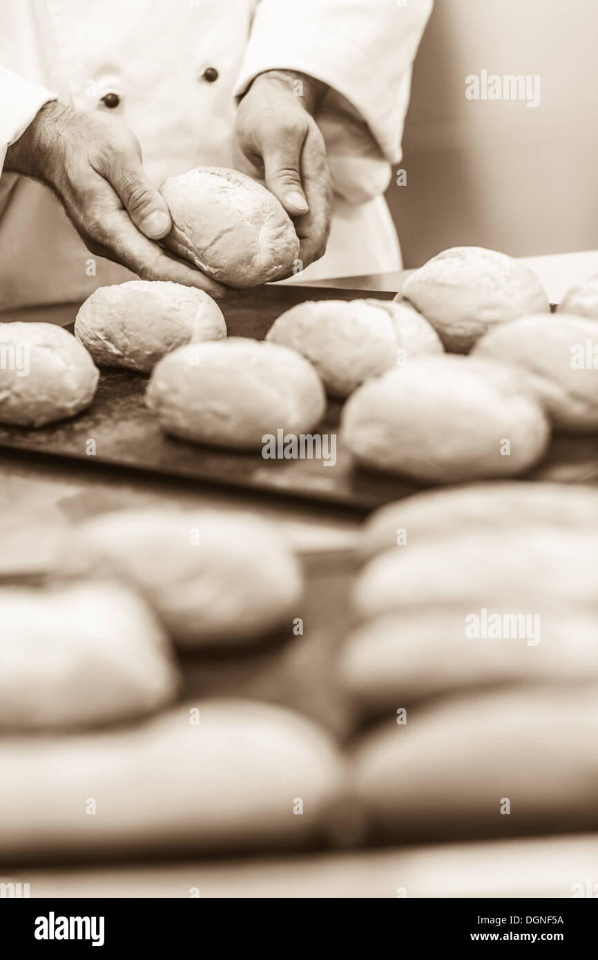 Maschio di formatura baker alcuni rotoli Foto Stock