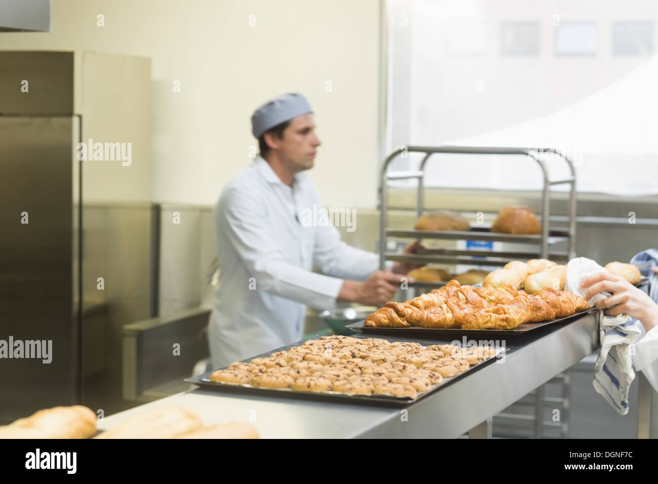 Giovane maschio baker lavora in una cucina Foto Stock