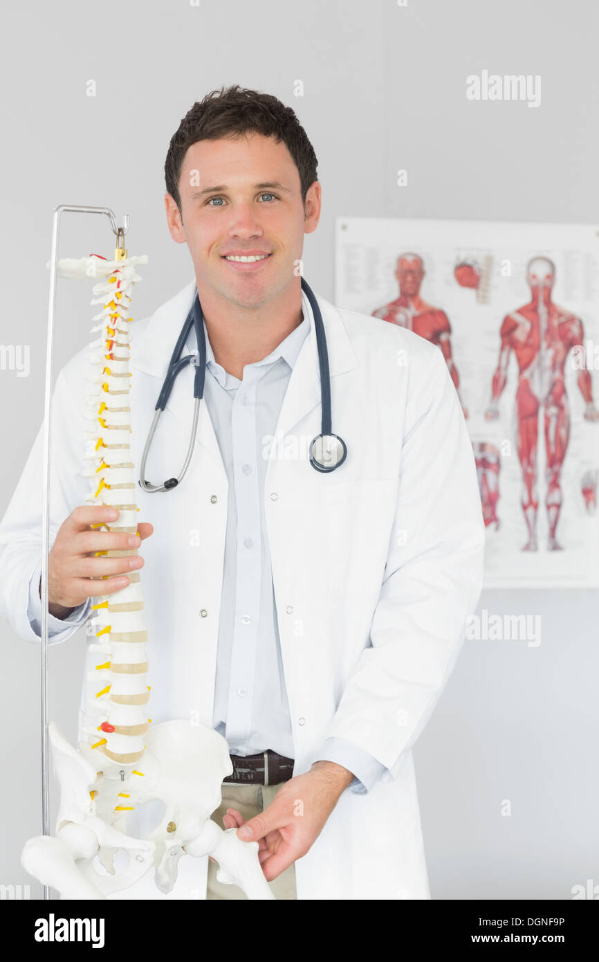 Bello sorridente medico azienda modello di scheletro Foto Stock