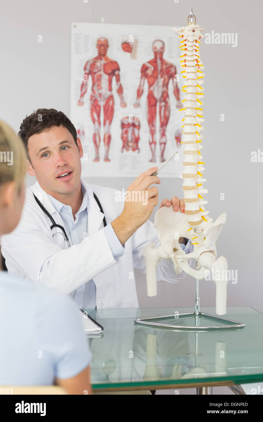 Attraente medico che mostra un paziente qualcosa sul modello dello scheletro Foto Stock