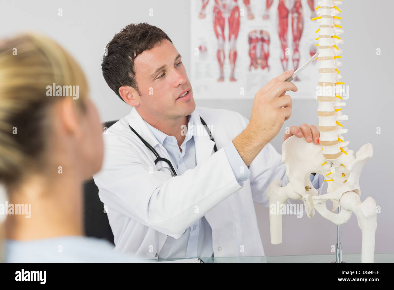 Buona ricerca medico che mostra un paziente qualcosa sul modello dello scheletro Foto Stock