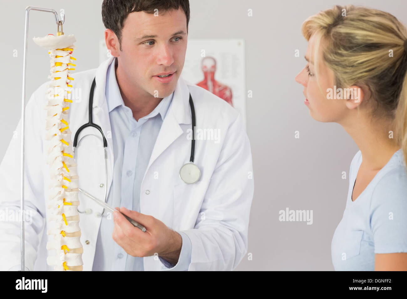 Un bell'aspetto medico che mostra un paziente qualcosa sul modello dello scheletro Foto Stock