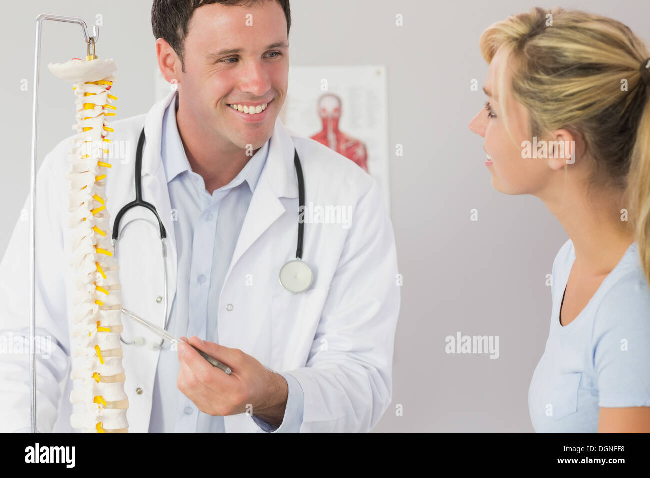 Lucky medico che mostra un paziente qualcosa sul modello dello scheletro Foto Stock