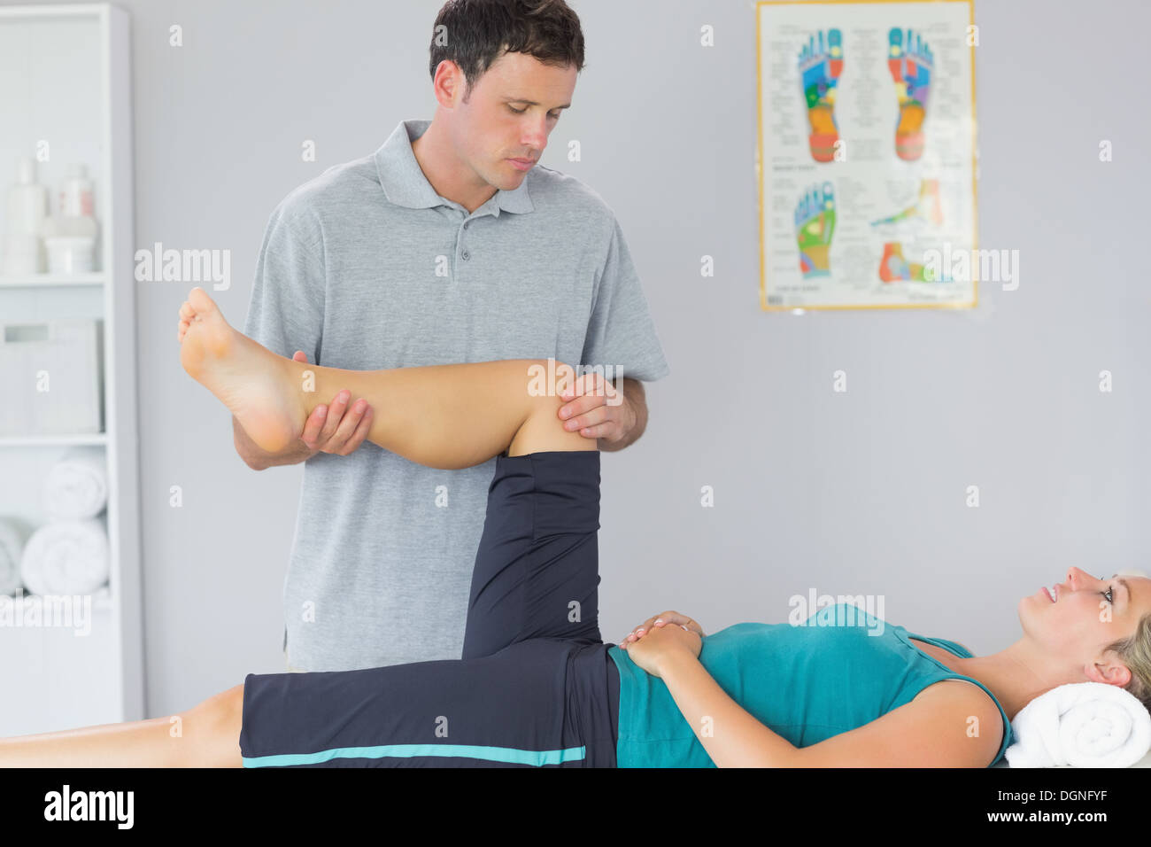 Buona ricerca fisioterapista il controllo di ginocchio di un paziente Foto Stock