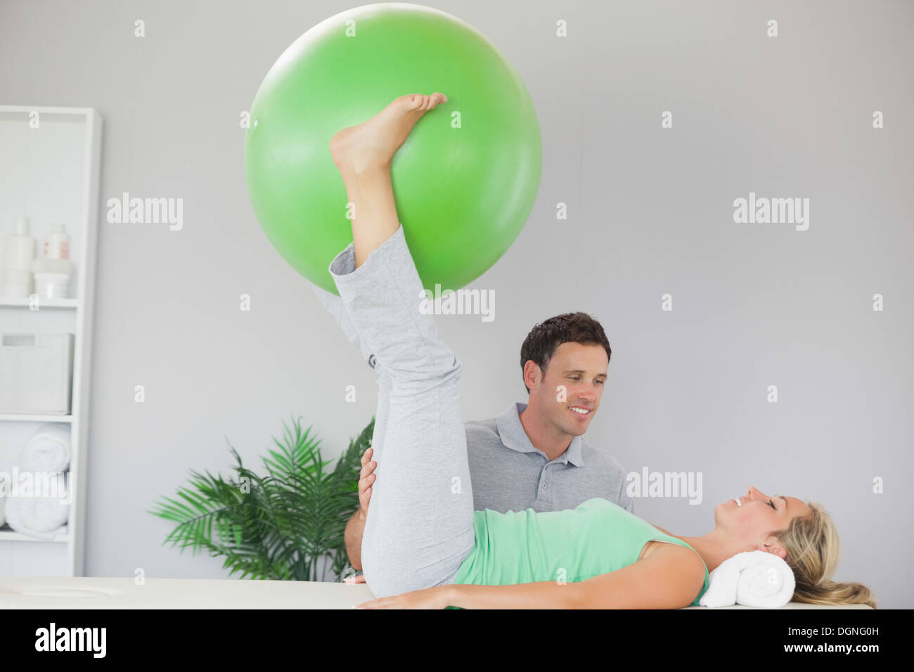 Paziente tenendo palla ginnica tra le gambe Foto Stock