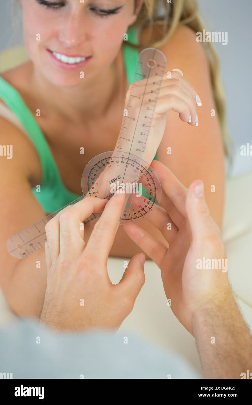 Fisioterapista controllo polso in pazienti con goniometro Foto Stock