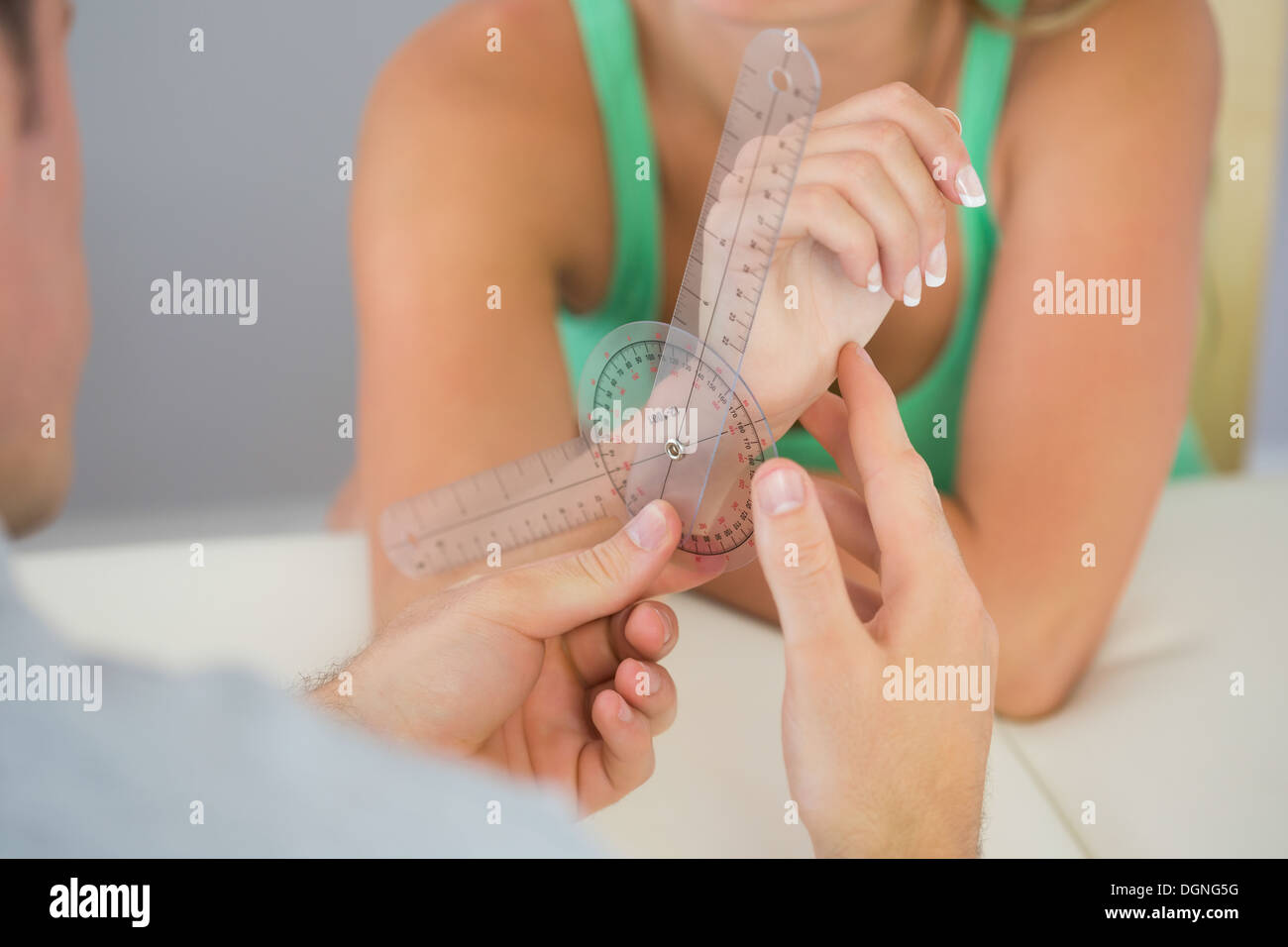 Fisioterapista esaminare pazienti polso con goniometro Foto Stock