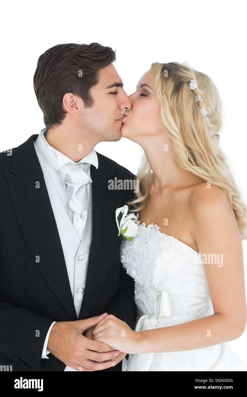 I giovani sposi in posa kissing ogni altro Foto Stock