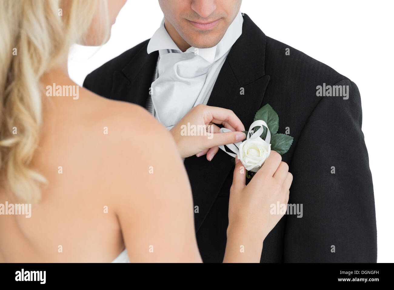 Bionda pinning sposa un fiore sulla tuta del suo marito Foto Stock