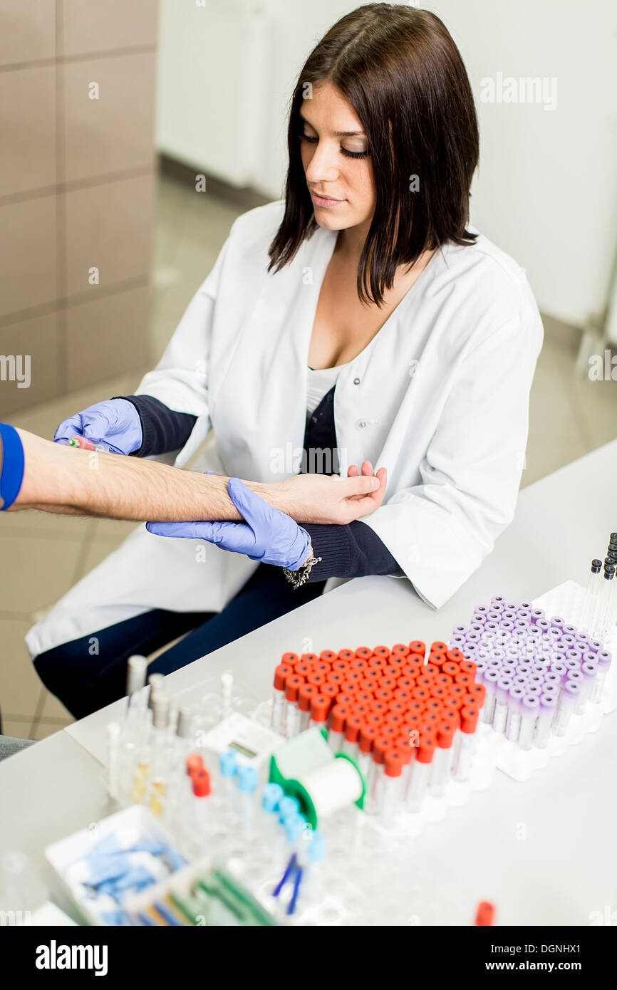 Giovane donna fare il prelievo di campioni di sangue in un moderno laboratorio di analisi mediche Foto Stock