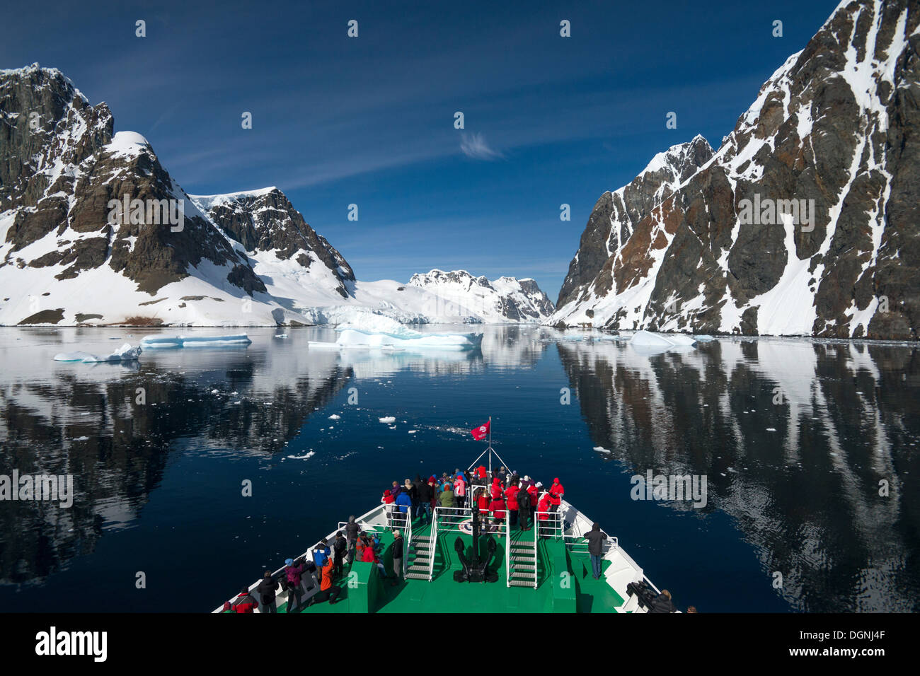 I visitatori sulla prua della Expedition nave da crociera, MS Expedition, osservando il paesaggio si riflette nel canale di Lemaire Foto Stock