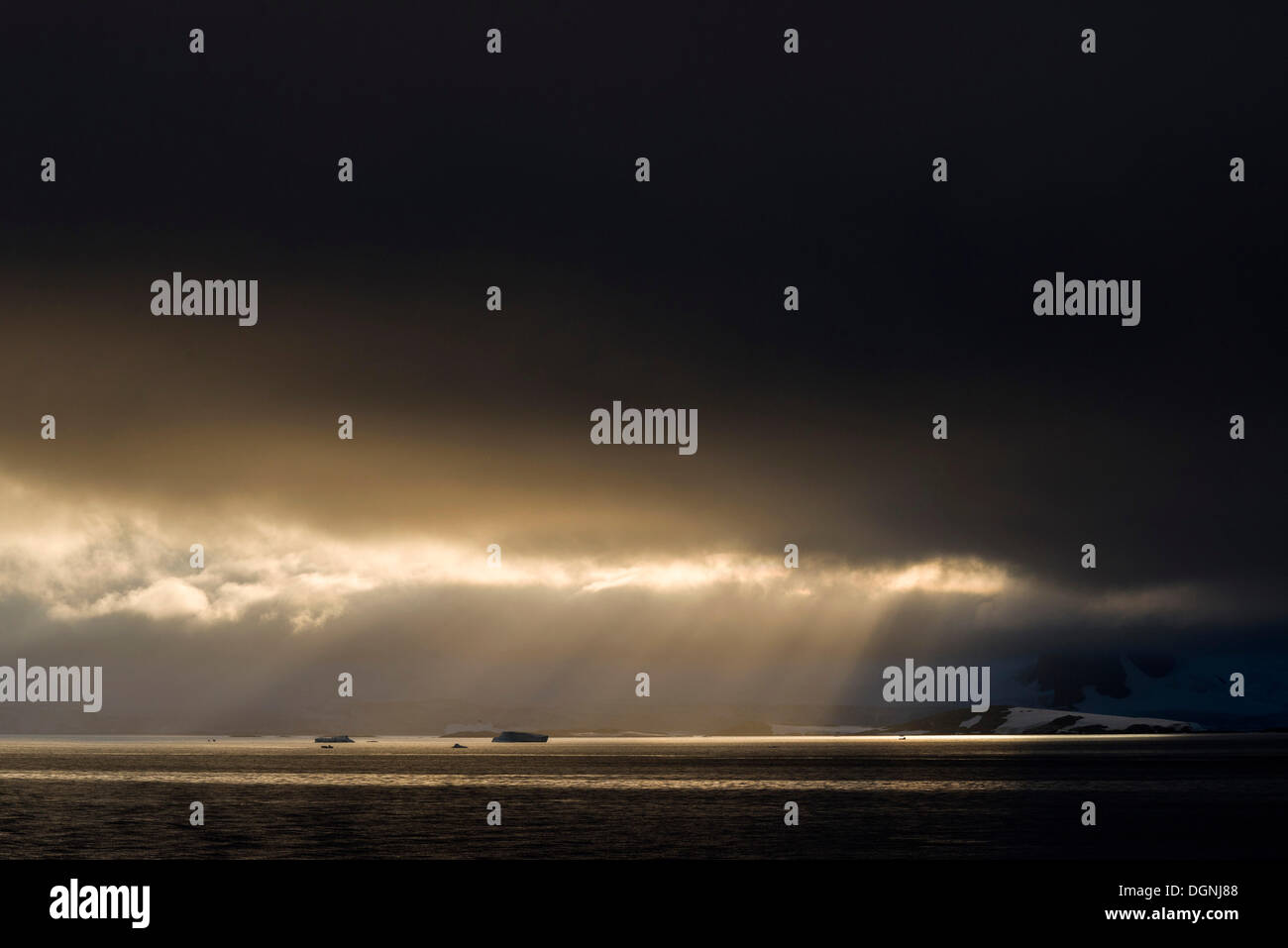 La luce del sole che splende attraverso un foro nelle nuvole, Errera Channel, Penisola Arctowski, Penisola Antartica, Antartide Foto Stock