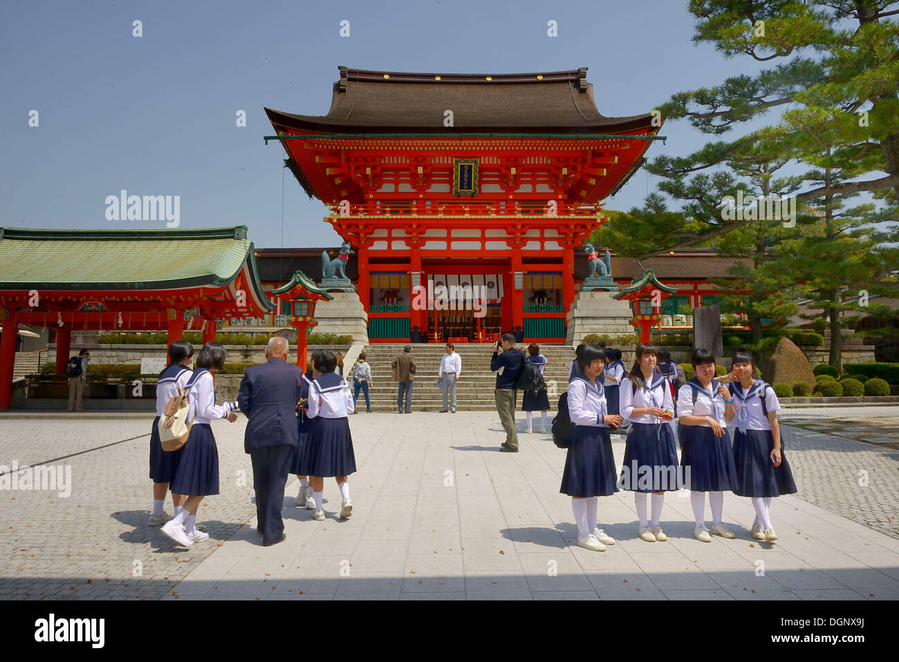 Gli studenti di sesso femminile sono in piedi al di fuori del rivellino di Fushimi Inari Taisha Sacrario scintoista, Fushimi, Kyoto Kinki regione, Giappone Foto Stock