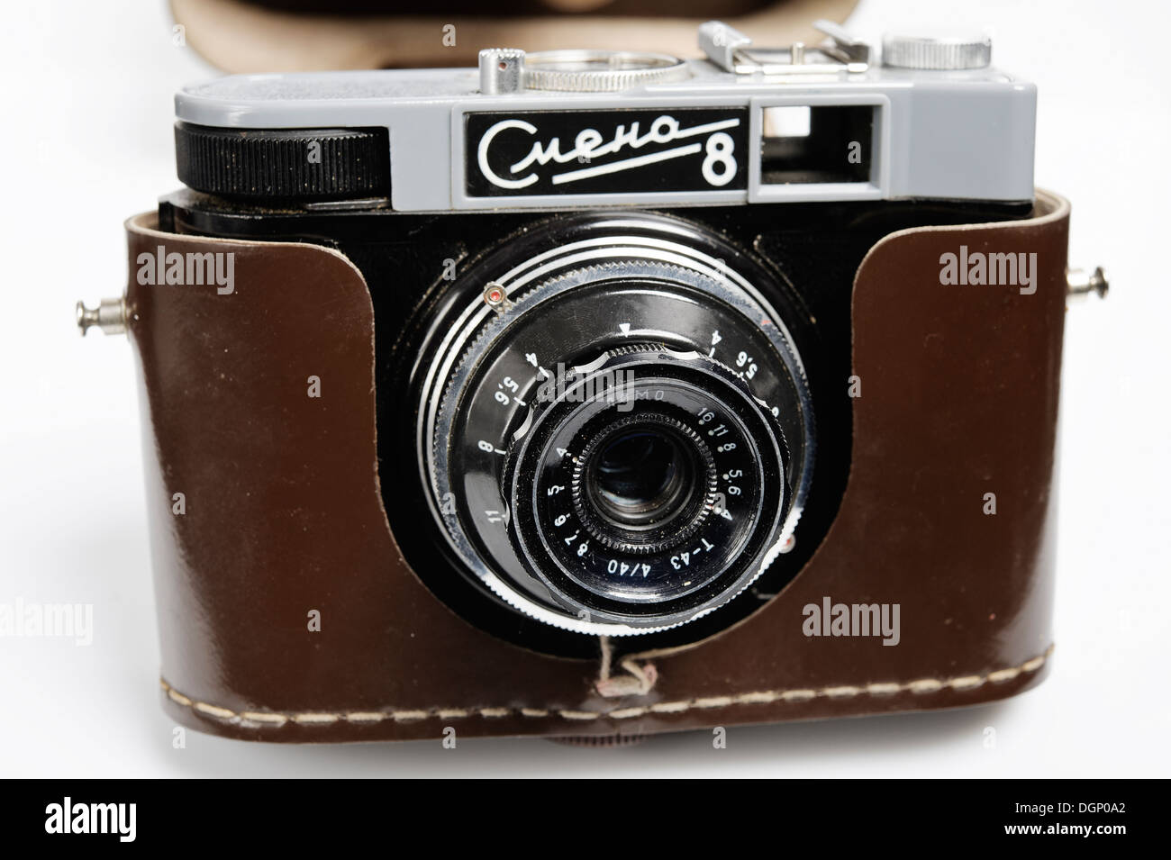 La lente di una fotocamera 35 mm. Apparecchiatura analogica e il negativo della pellicola. Lente sullo sfondo luminoso. Foto Stock