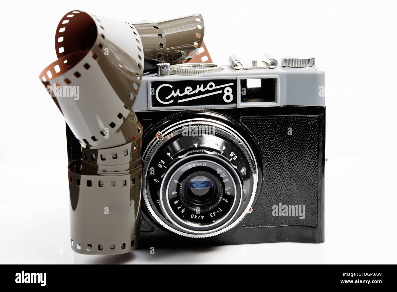 La lente di una fotocamera 35 mm. Apparecchiatura analogica e il negativo della pellicola. Lente sullo sfondo luminoso. Foto Stock