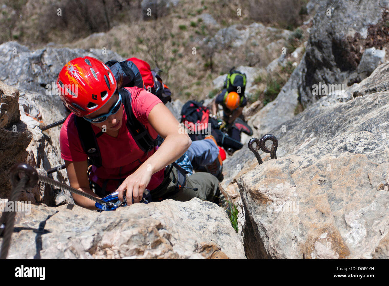 Gli arrampicatori salendo una via ferrata sul Monte Albano al di sopra di Mori, Trentino, Italia, Europa Foto Stock