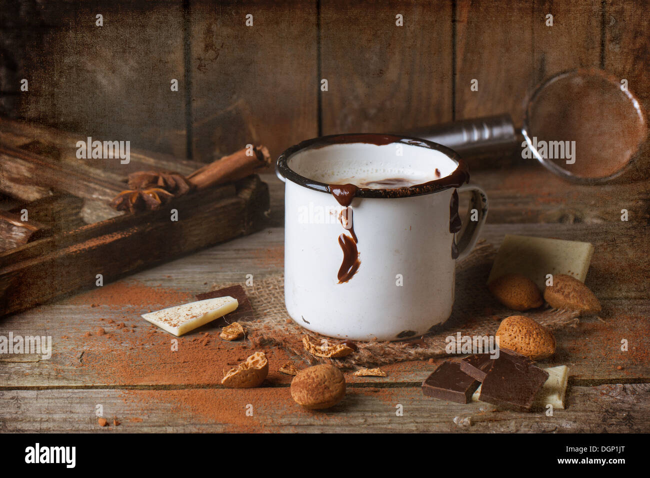 Vintage fotografia della tazza di cioccolata calda servita con pezzetti di bianco e il cioccolato fondente e mandorle sul vecchio tavolo in legno Foto Stock