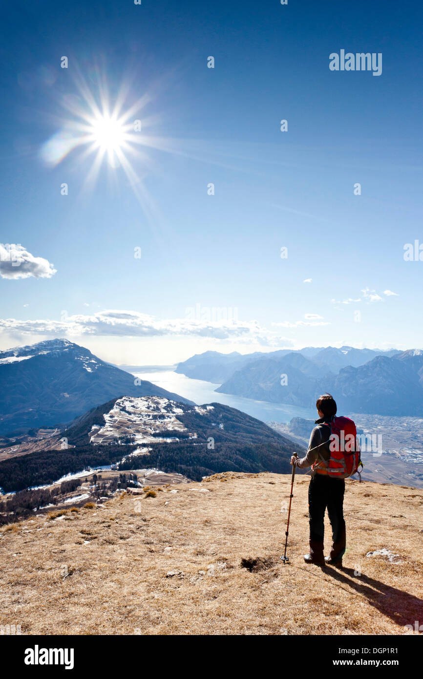 Escursionista durante la salita del Monte Stivo, il Lago di Garda con il villaggio di riva sul retro, Alpen, Trentino Provincia Foto Stock