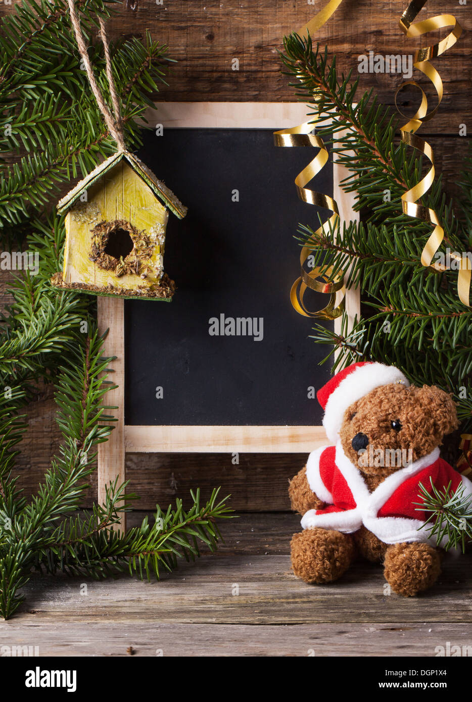 Decorazione di natale con antichi orsacchiotto in santa del cappello con il fustellato di ardesia e scatola di nidificazione su sfondo di legno Foto Stock