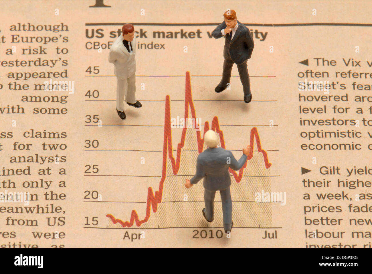 Gli imprenditori in miniatura le figure in piedi su un mercato azionario grafico Foto Stock