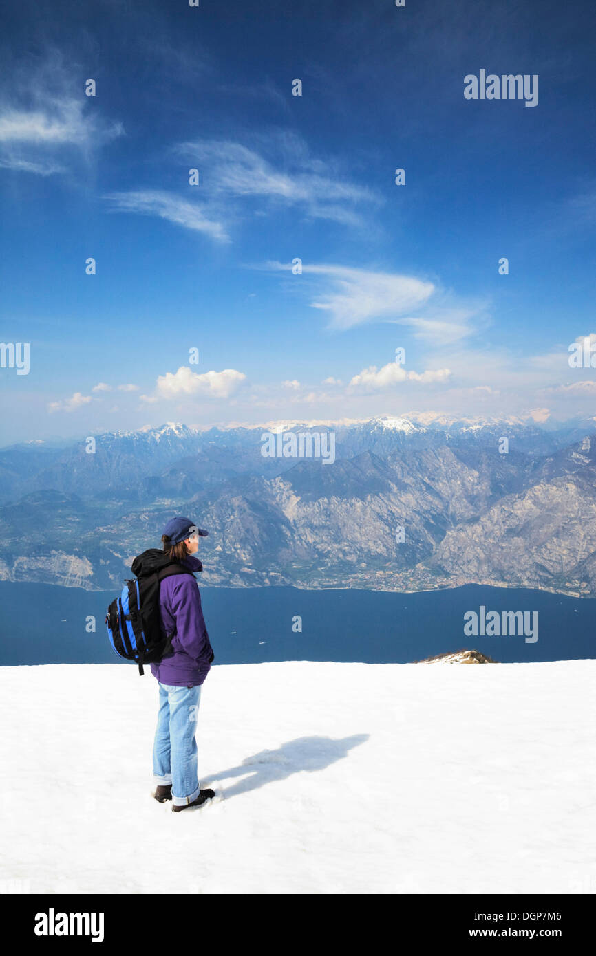 Escursionista godendo la vista dal Monte Baldo sul Lago di Garda e le Alpi, il Lago di Garda, Lombardia, Italia, Europa Foto Stock