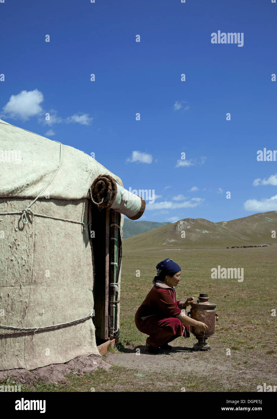 Donna di apertura del rubinetto di una brocca di acqua nella parte anteriore della sua Yurt, Jaman Echki Jailoo Village, Song Kol Area, Kirghizistan Foto Stock
