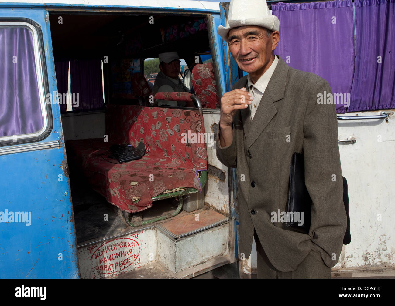 Il vecchio uomo Con Kalpak Hat Ottenere in un minibus, Kochkor mercato animale, Kirghizistan Foto Stock