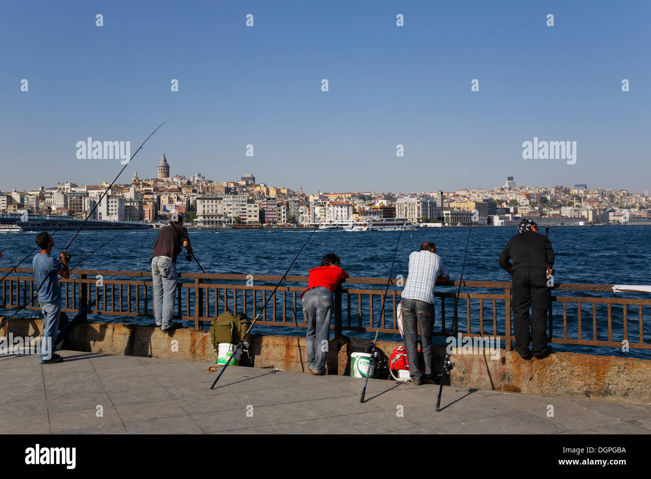 I pescatori in Eminönü, Golden Horn, con Beyoglu nella parte posteriore, Istanbul, parte europea, Turchia, Europa PublicGround Foto Stock