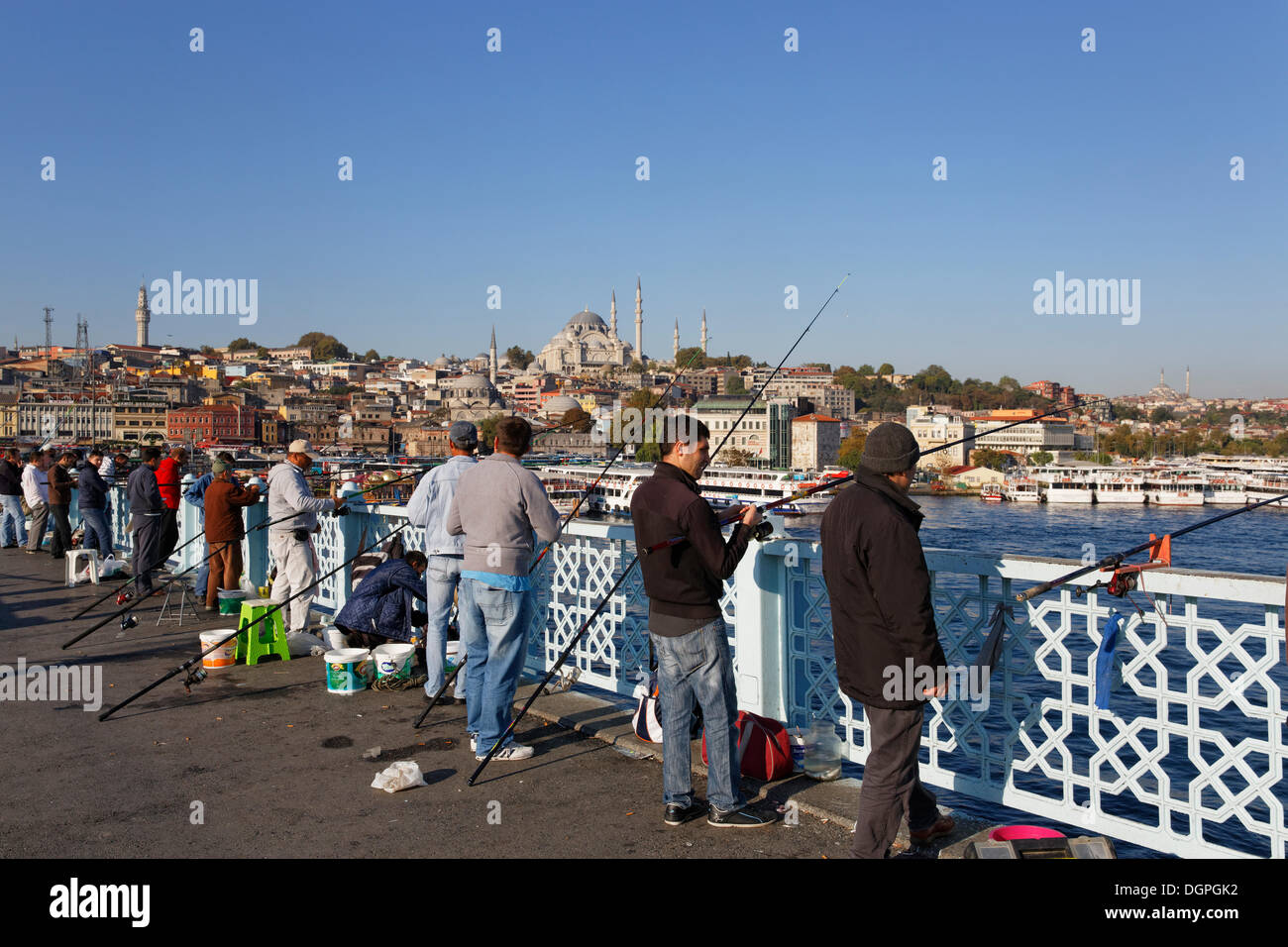 I pescatori in piedi sul Ponte di Galata, Ponte Galata, Golden Horn, Moschea Sueleymaniye sul retro, Istanbul, lato europeo Foto Stock