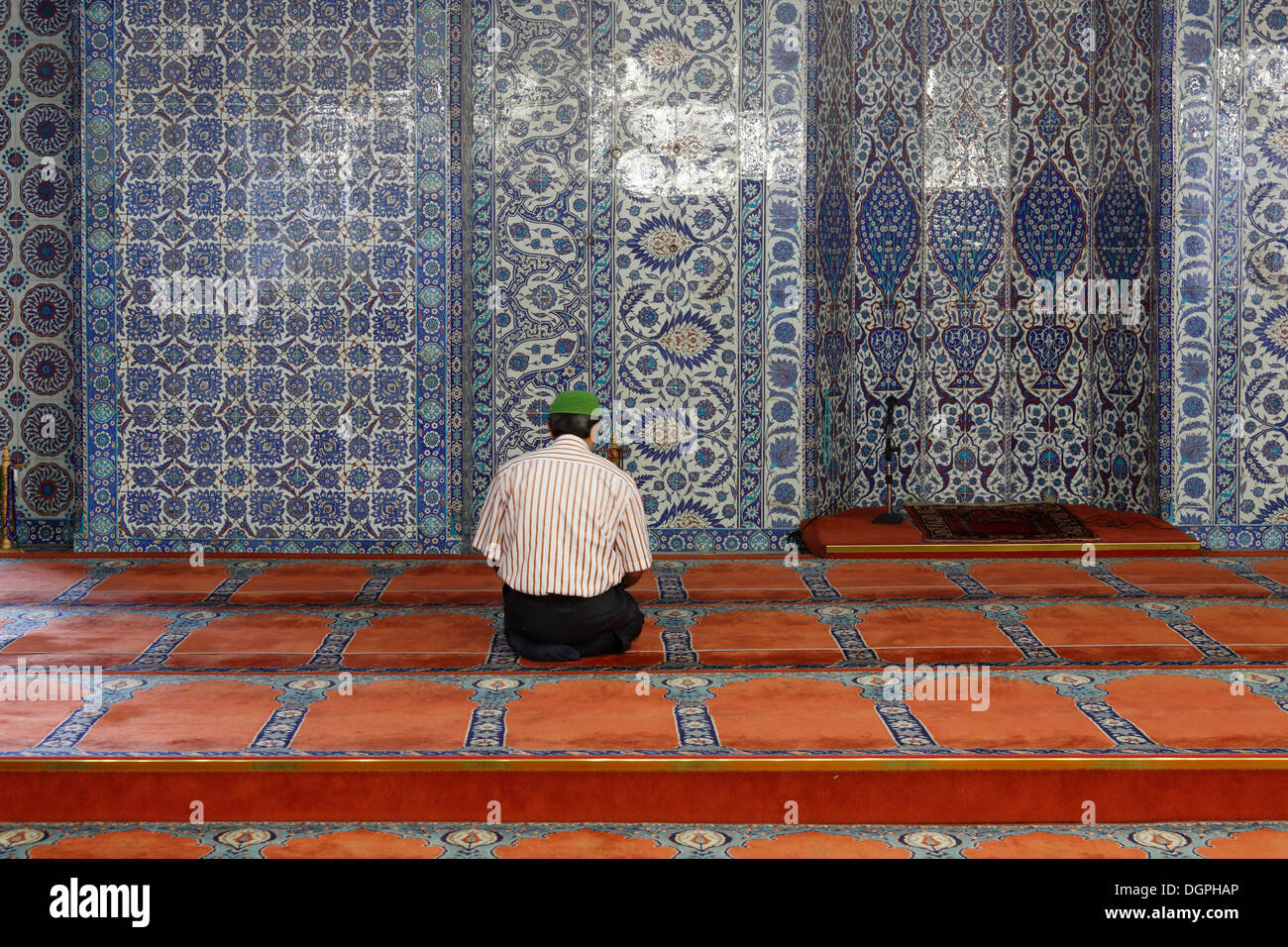 Uomo in preghiera di fronte ad una parete con il signor Iznik faience piastrelle, Ruestem Pasha moschea, Eminönü, Istanbul, lato europeo Foto Stock