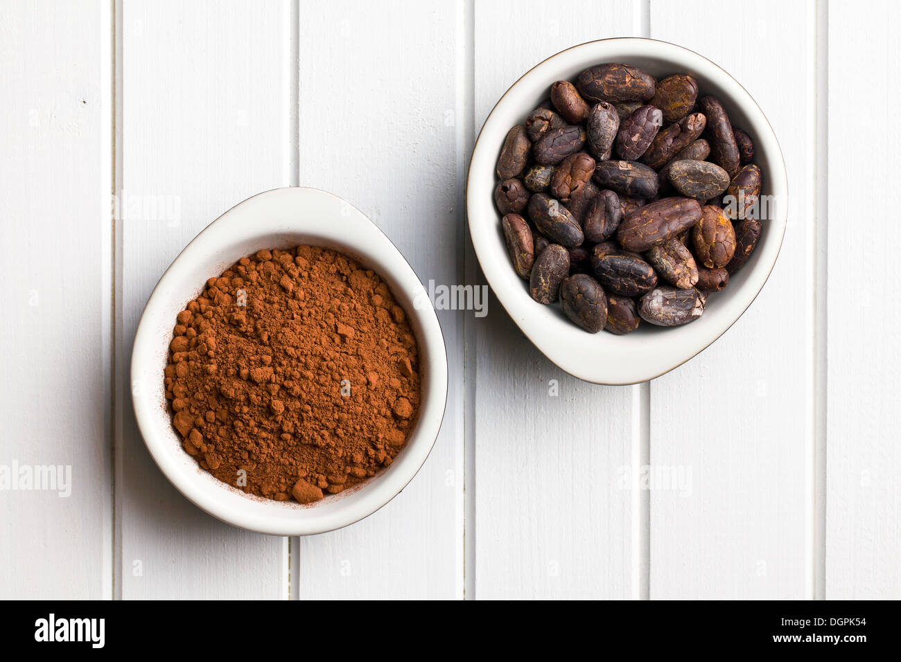 Vista superiore delle fave di cacao e polvere di cacao in ciotole Foto Stock