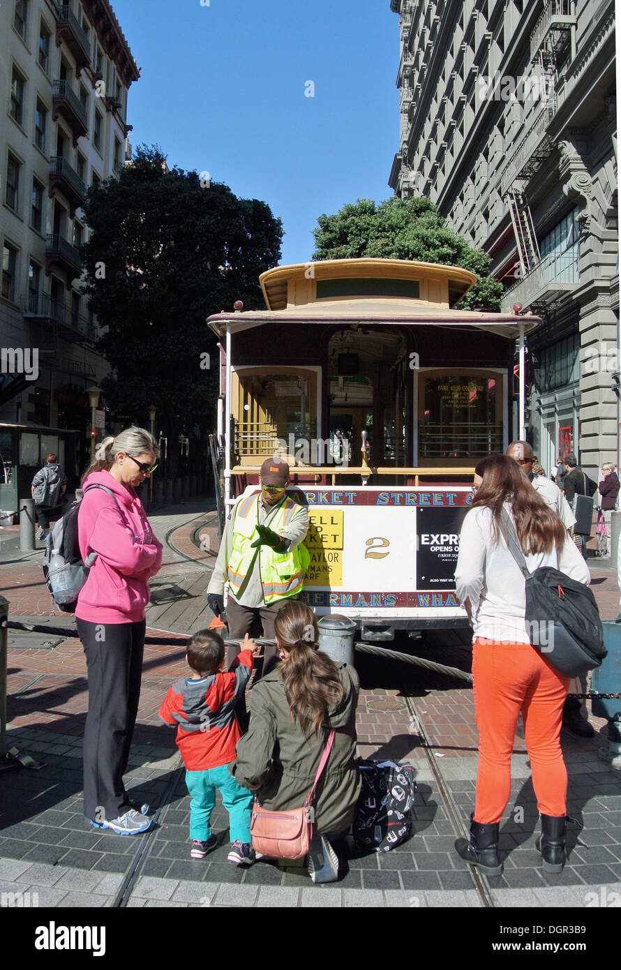 I turisti orologio uomo presa cavo girare auto intorno a Powell Street Foto Stock