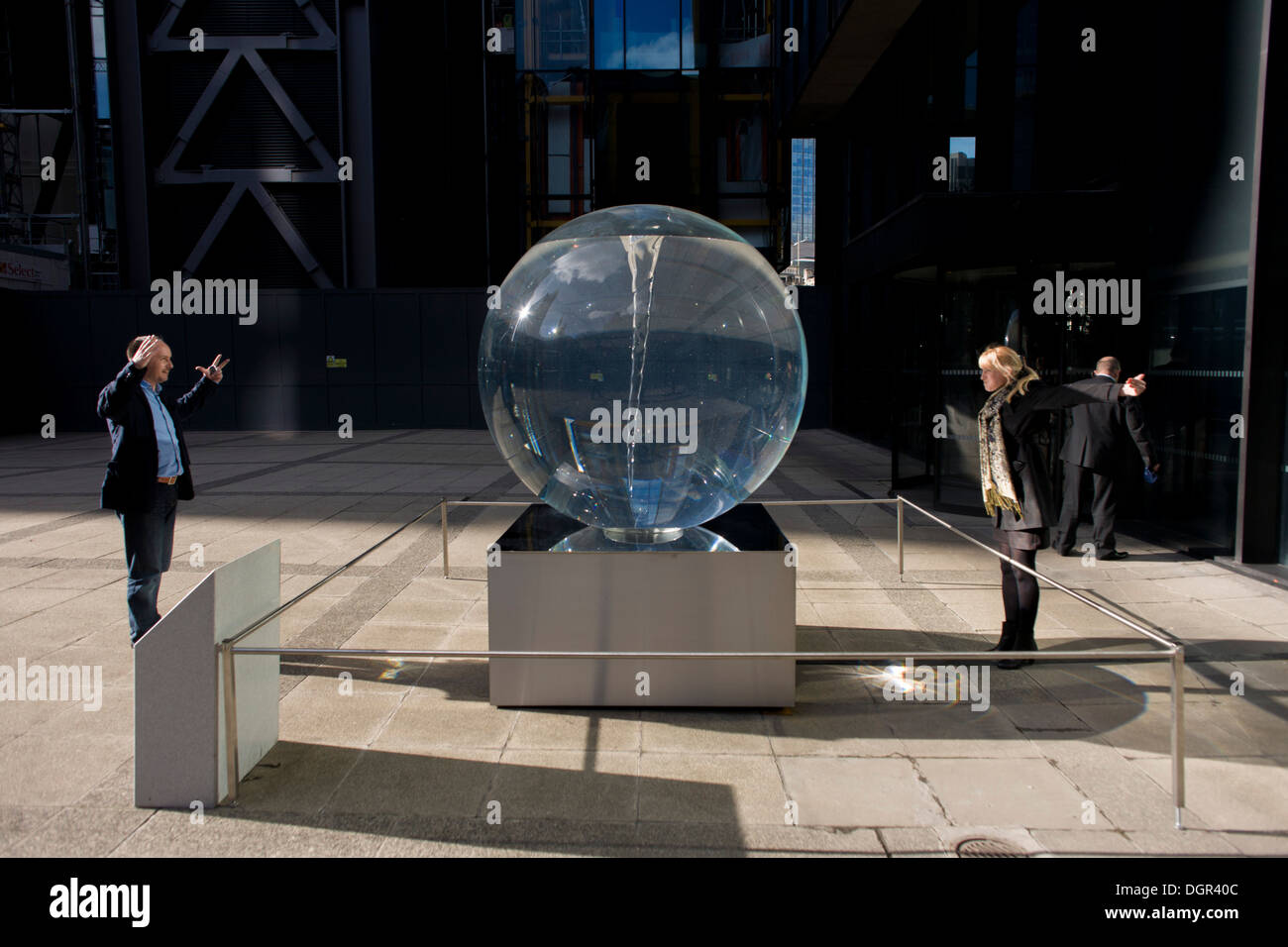 Distorsione visto attraverso Petroc Sesti di instillazione di arte chiamato tempo piega nella grande Helen Square nella città di Londra. Una coupé guardare a ogni altro ingrandito le teste e le braccia tese attraverso le ottiche di questa arte prisma. Petroc Sesti è una base a Londra artista britannico e ora si piega piega la luce come un prisma, hypnotising visualizzatore riflettendo sulla sua mutevole moto a spirale. Foto Stock