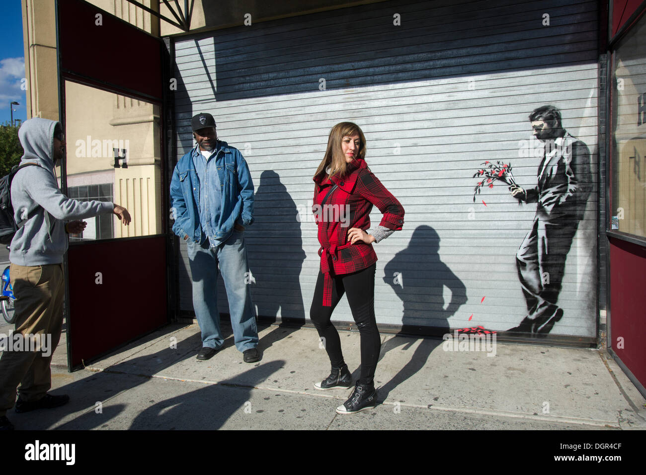 Street appassionati d arte gregge di Larry Flynt's Hustler Club di Hells Kitchen quartiere di New York il Giovedi, Ottobre 24, 2013 per vedere "aspettando invano" la ventiquattresima rata di Banksy graffiti dell'arte. La stampata artwork è sul roll-up porta d'ingresso al gentlemen's club, che ha inviato le guardie di sicurezza al di fuori di proteggere il loro nuovo capolavoro. Il fantomatico artista di strada è la creazione di opere intorno alla città ogni giorno durante il mese di ottobre è chiamato "Meglio fuori rispetto all'. (© Francesca M. Roberts) Foto Stock