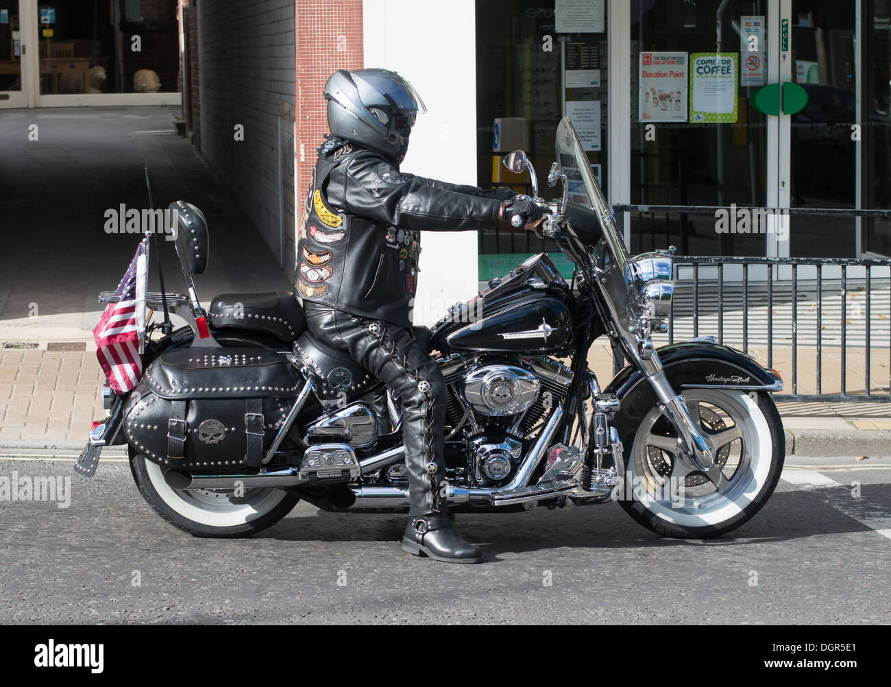 Un nero rivestito di pelle motociclista a cavallo di una Harley Davidson Moto Otley, nello Yorkshire, Inghilterra, Regno Unito Foto Stock