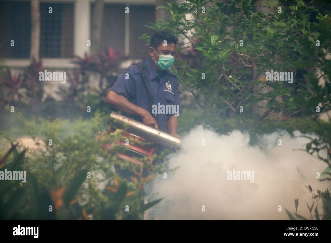 Un controllo di peste lavoratore fumigates o nebbie, un condominio residenziale contro zanzare di Kuala Lumpur in Malesia Foto Stock