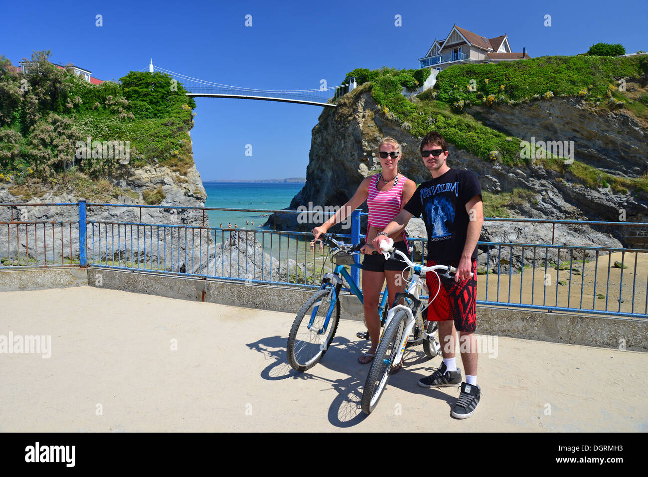 Coppia giovane con le biciclette da Towan Beach, Newquay Cornwall, England, Regno Unito Foto Stock