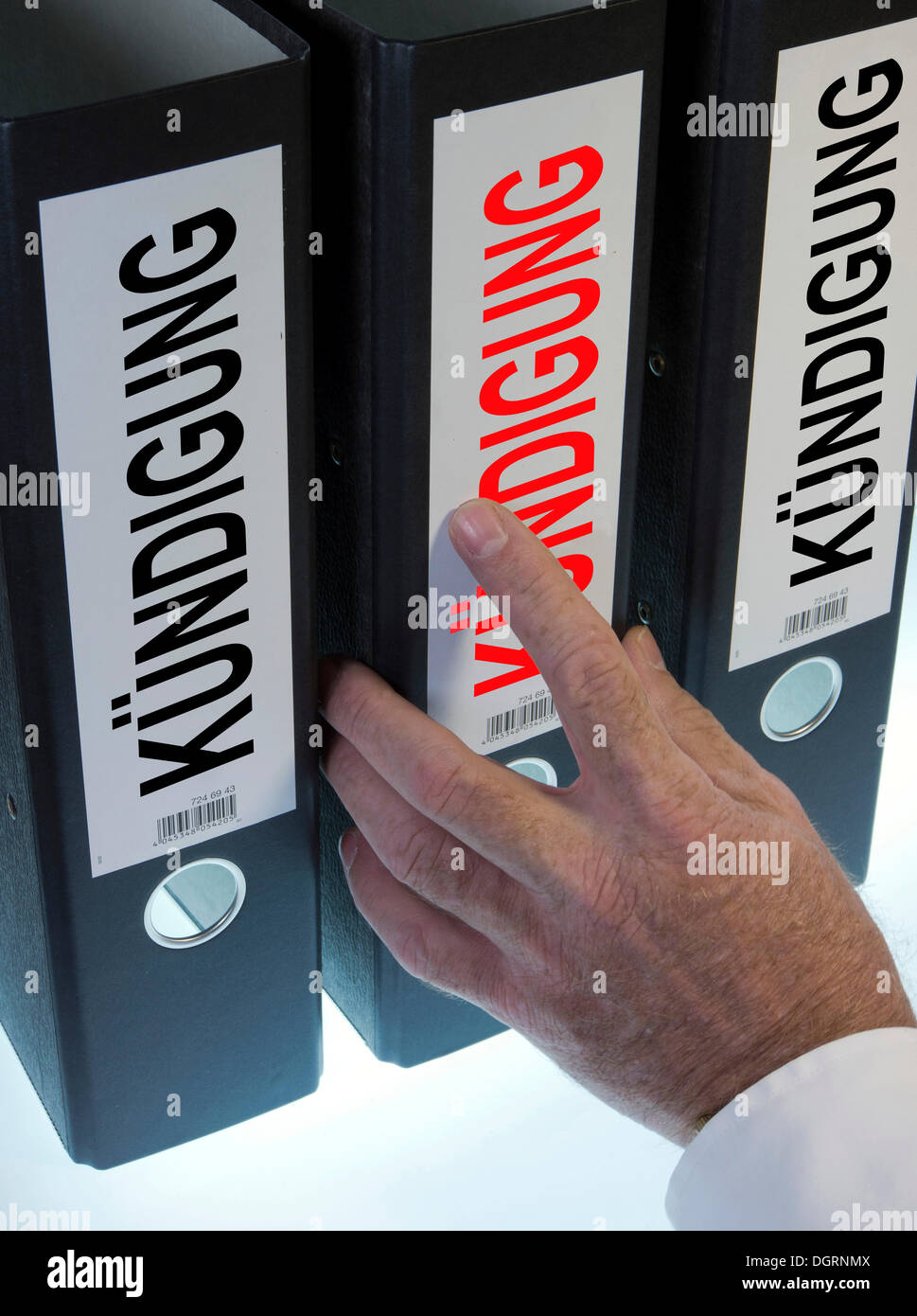 La mano di raggiungere per una cartella di file denominata "Kuendigung', tedesco per "lay-off' o 'Cancellazione' Foto Stock